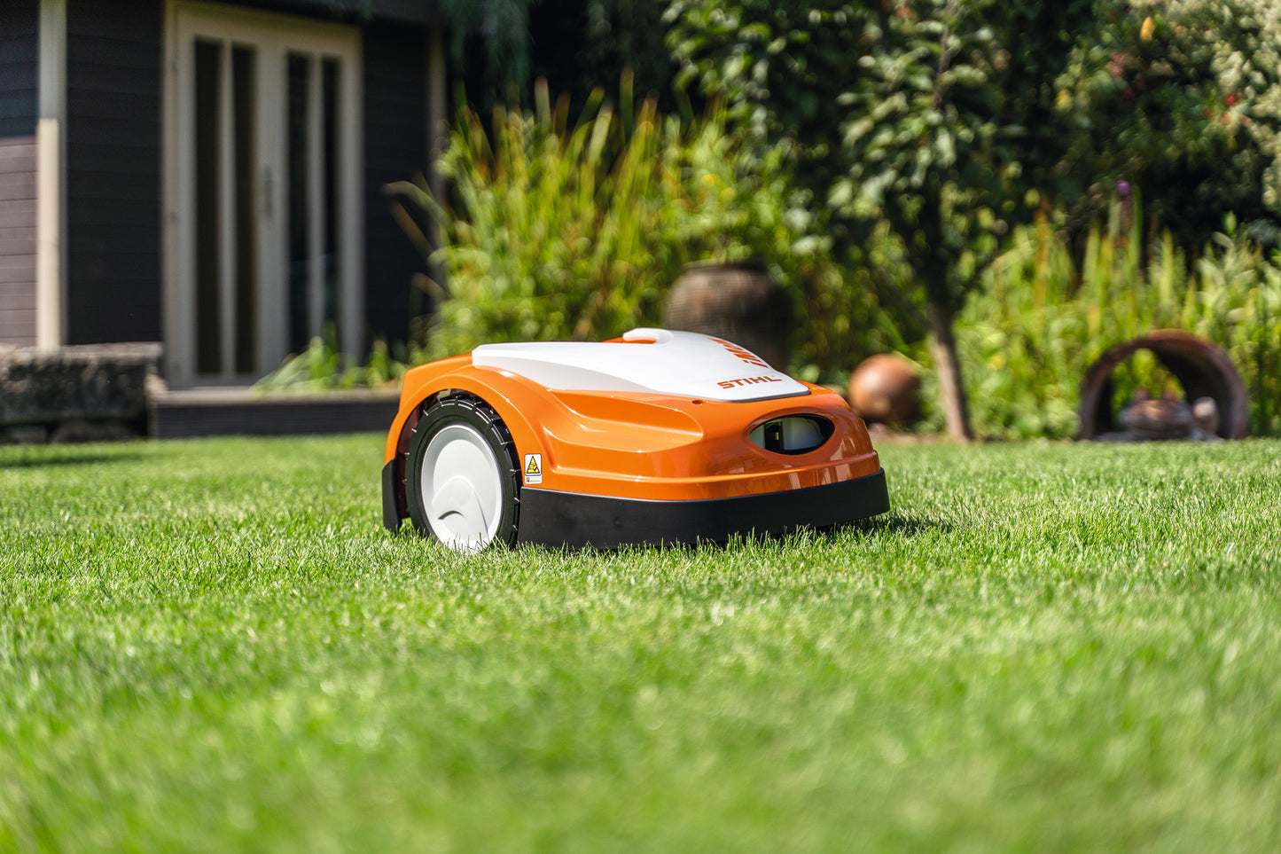 Robot Tosaerba Stihl RMI 422 P in azione su un prato, evidenziandone la capacità di lavorare su terreni collinari