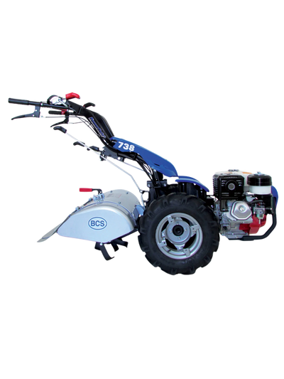 Motocoltivatore BCS PowerSafe 738 con attacco fresatrice e pneumatici robusti, ideale per lavori agricoli e di giardinaggio. Design in colore blu con motore a benzina visibile sulla destra.